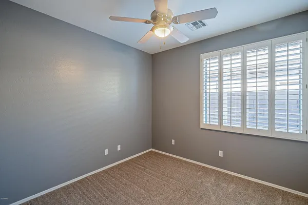 an empty room with closet and chandelier fan