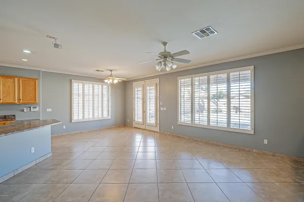 a view of an empty room with a window and kitchen view