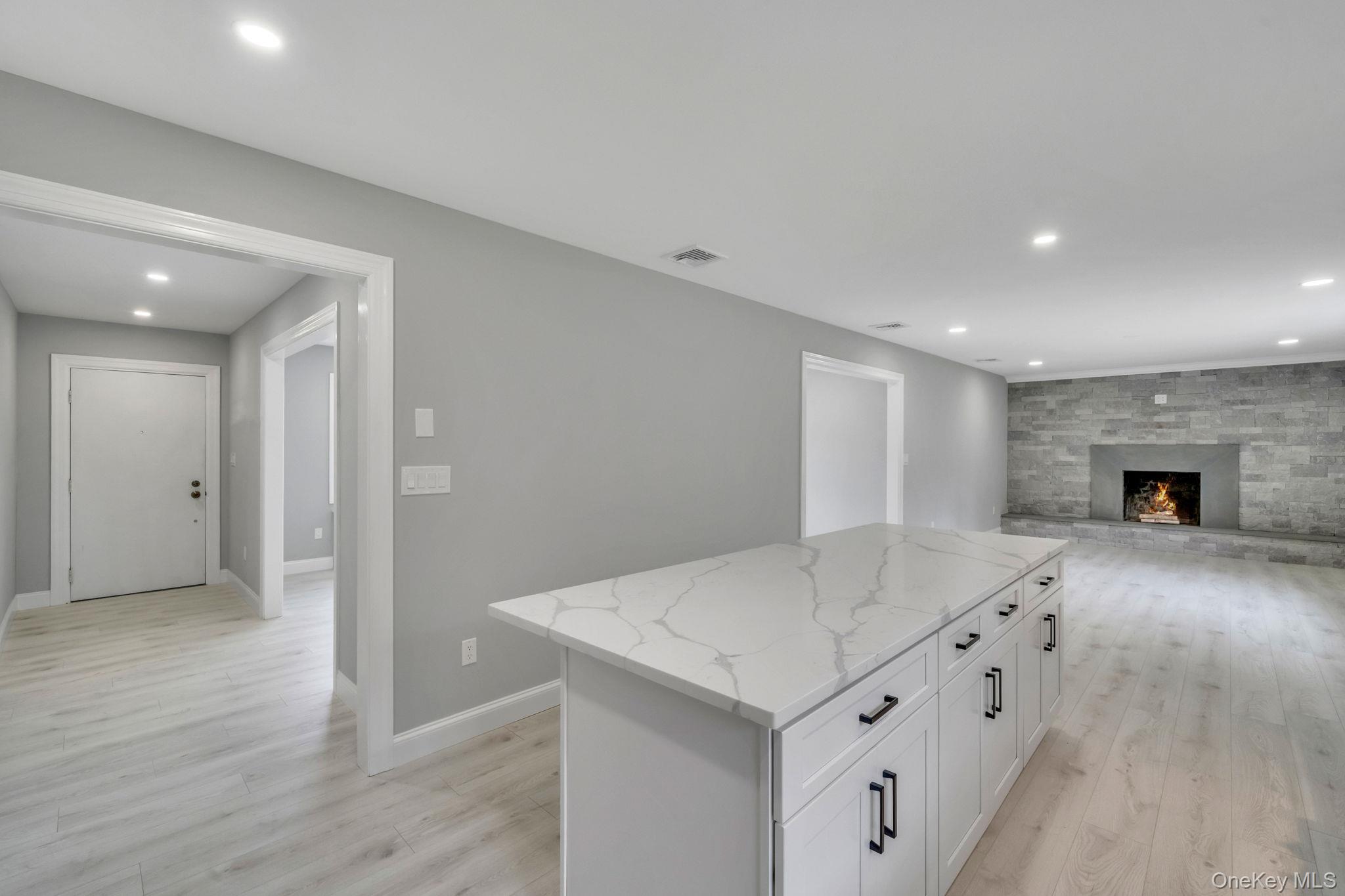 827 Aberdeen Road West Bay Shore, NY 11706 - Photo 12 of 40 Kitchen featuring recessed lighting, a center island, light stone countertops, light wood-style floors, and white cabinets