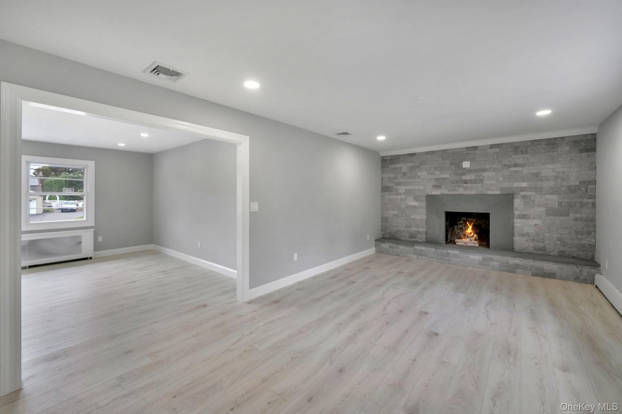 827 Aberdeen Road West Bay Shore, NY 11706 - Photo 13 of 40 Unfurnished living room featuring light wood-style floors, recessed lighting, and a fireplace