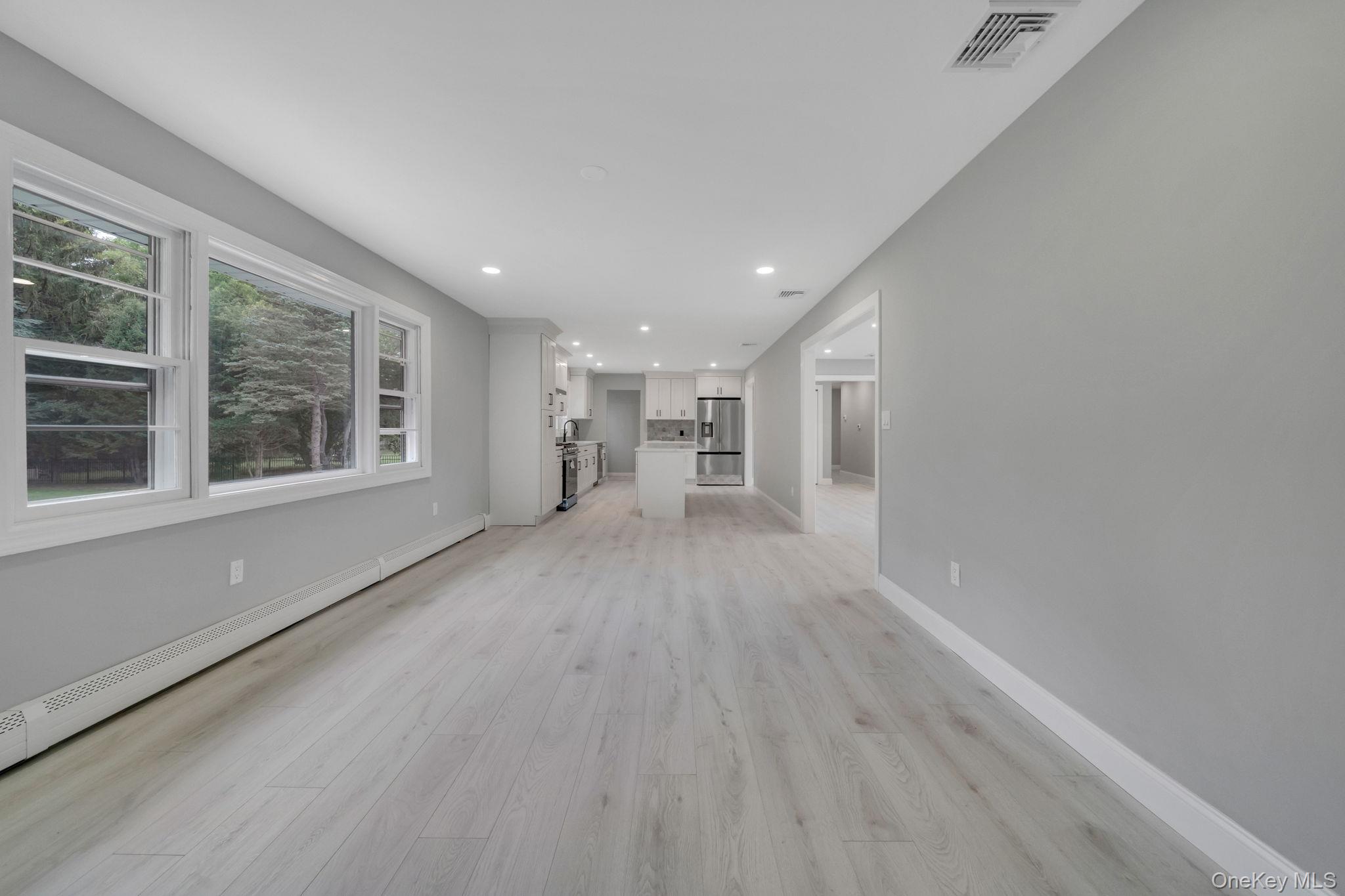 827 Aberdeen Road West Bay Shore, NY 11706 - Photo 14 of 40 Unfurnished living room featuring recessed lighting, light wood finished floors, and a baseboard heating unit