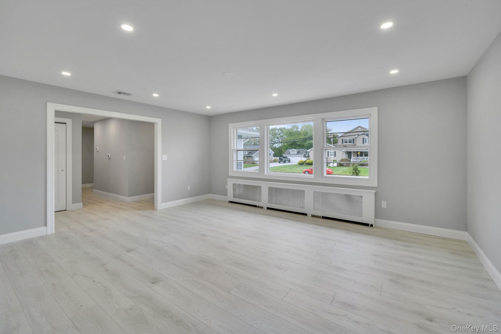 827 Aberdeen Road West Bay Shore, NY 11706 - Photo 15 of 40 Empty room with recessed lighting, radiator, and light wood-style floors