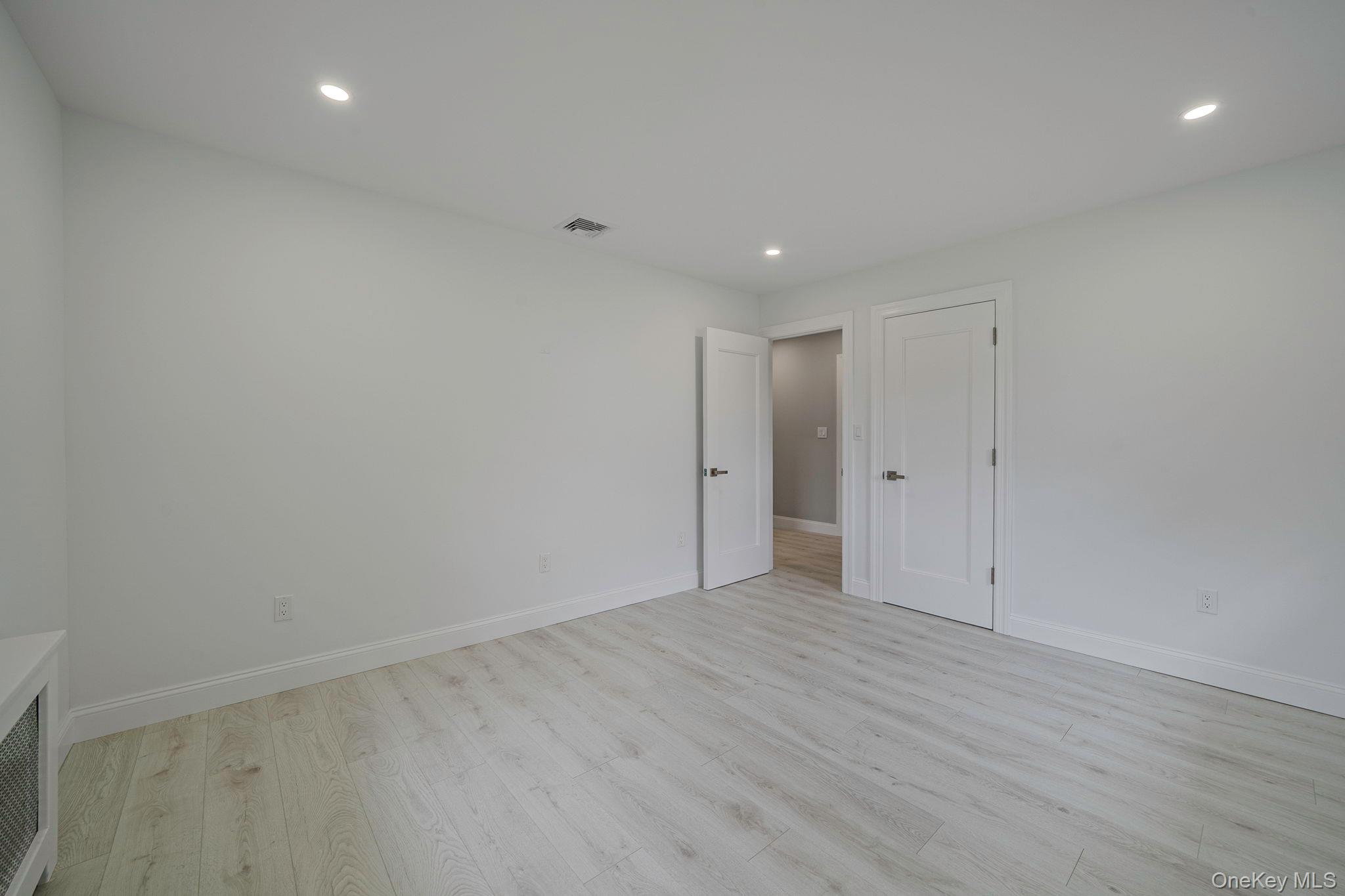 827 Aberdeen Road West Bay Shore, NY 11706 - Photo 26 of 40 Unfurnished bedroom with light wood finished floors, recessed lighting, and radiator heating unit