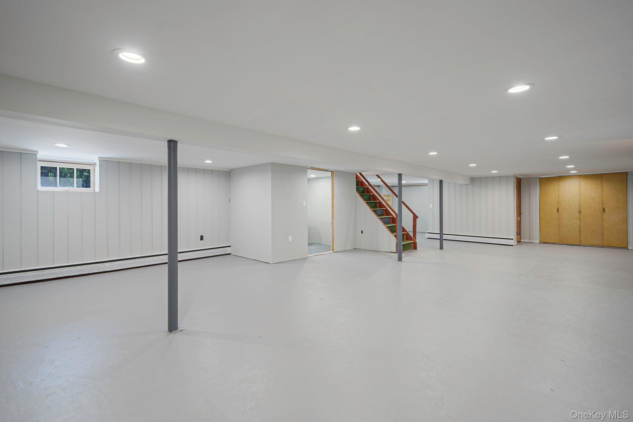 827 Aberdeen Road West Bay Shore, NY 11706 - Photo 30 of 40 Below grade area with wooden walls, recessed lighting, a baseboard radiator, and stairway