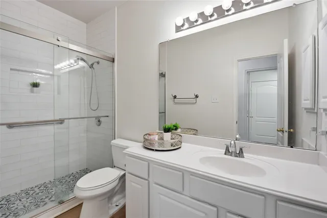 a bathroom with a sink mirror vanity and toilet