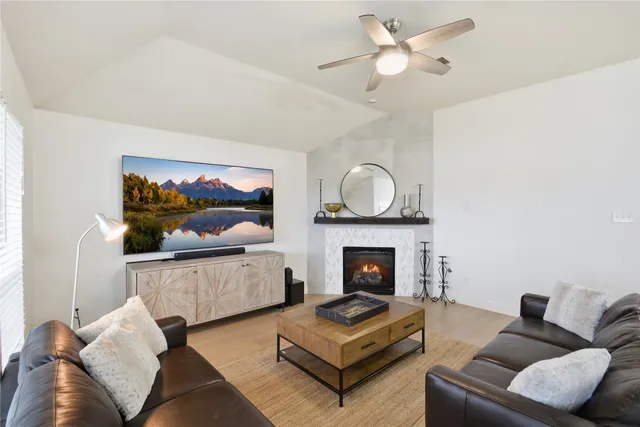 a living room with furniture a flat screen tv and a fireplace