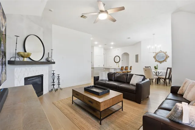 a living room with furniture a fireplace and a ceiling fan