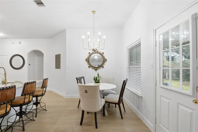 a view of a dining room with furniture and chandelier