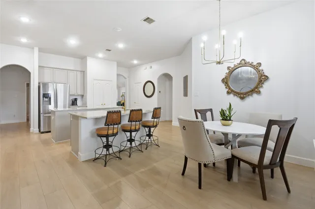 a dining room with kitchen island furniture a chandelier and a rug