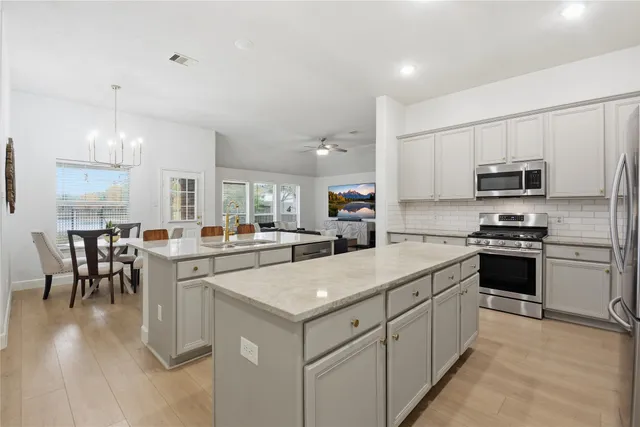 a kitchen with appliances a sink and cabinets
