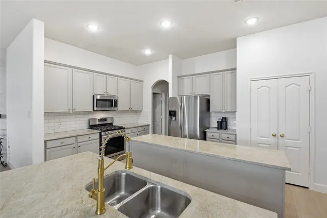 a kitchen with stainless steel appliances a sink stove and refrigerator