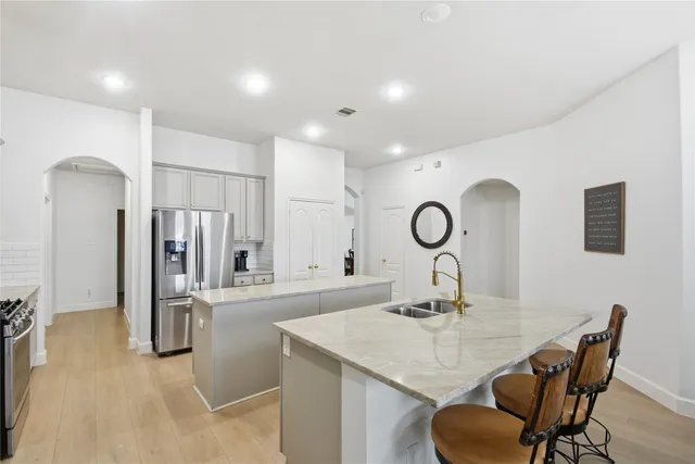 a kitchen with stainless steel appliances granite countertop a sink a stove and a refrigerator