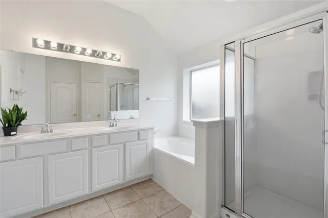 a spacious bathroom with a double vanity sink and mirror