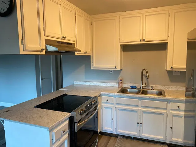 a kitchen with stainless steel appliances granite countertop a sink stove and cabinets