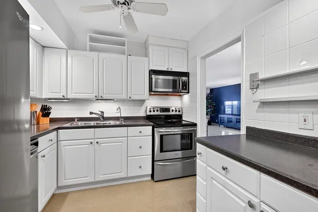 a kitchen with granite countertop a sink stainless steel appliances and cabinets