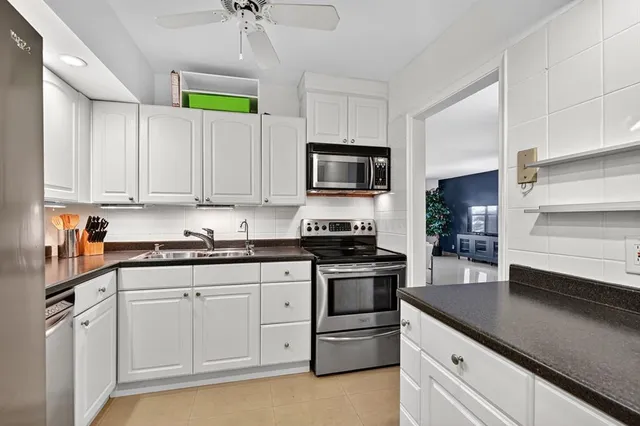 a kitchen with granite countertop a sink stainless steel appliances and cabinets