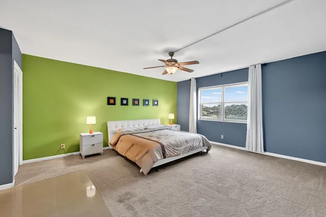 a bed sitting in a spacious bedroom next to a window