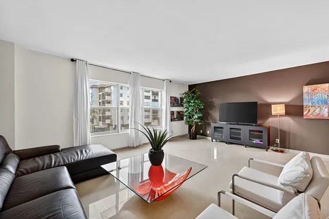 a living room with furniture potted plant and a flat screen tv