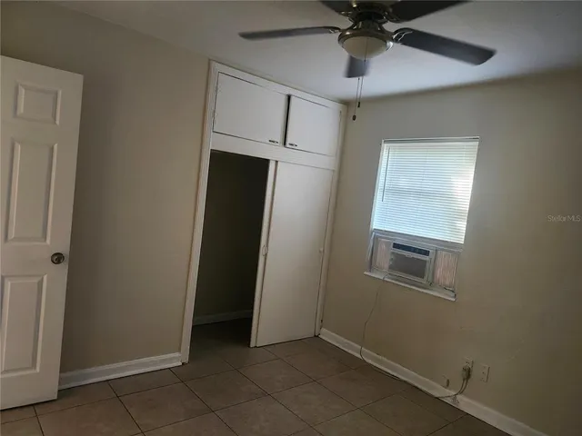an empty room with a ceiling fan and carpet