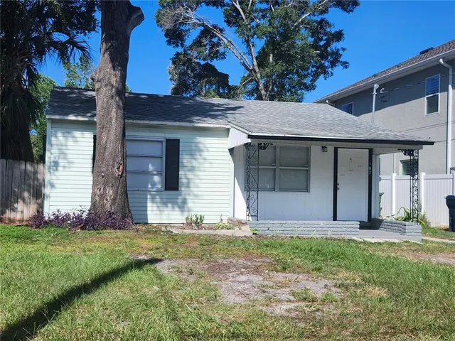 a view of a house with yard and tree