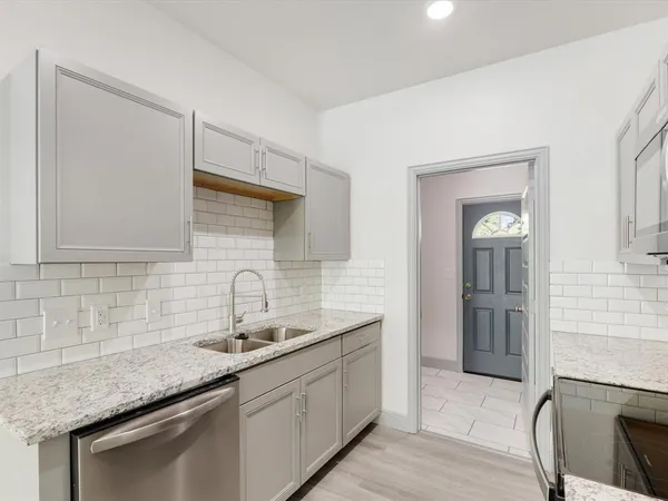 a kitchen with stainless steel appliances granite countertop a sink and dishwasher a stove with wooden floors