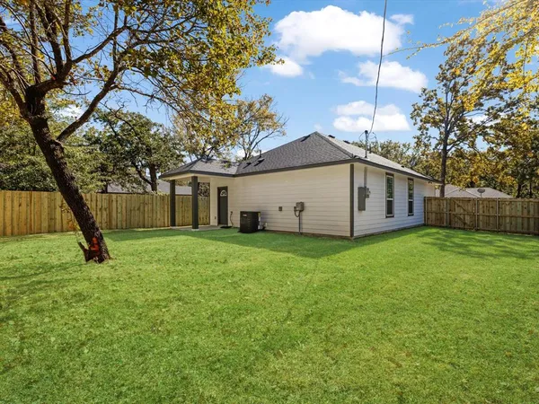 a view of a house with backyard and a tree