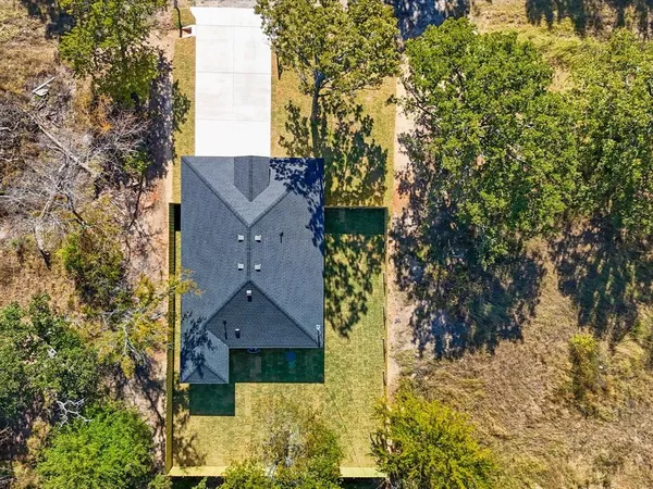 a aerial view of a house with a yard and large tree