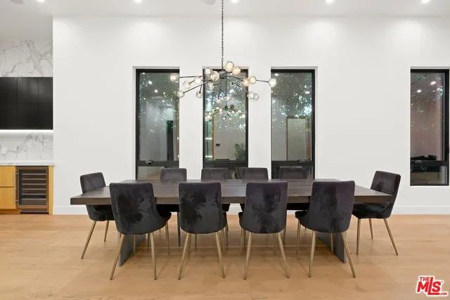 a view of a dining room with furniture a chandelier and wooden floor
