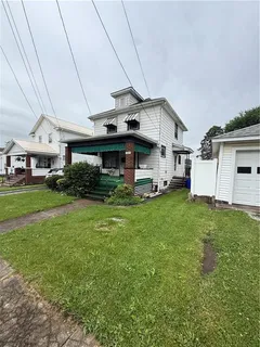 a front view of a house with a yard porch and a garage
