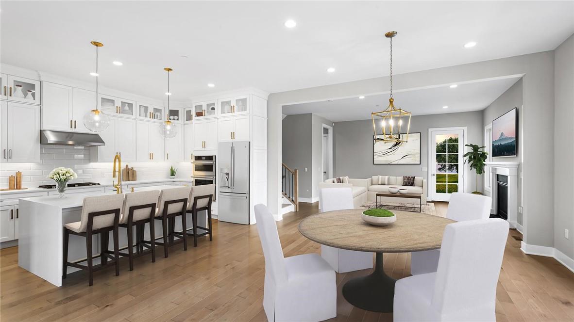 a view of a dining room and livingroom with furniture wooden floor a chandelier