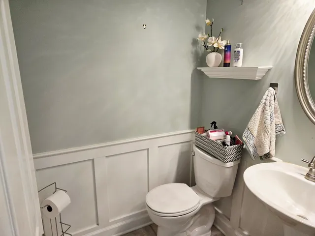 a bathroom with a toilet sink and mirror