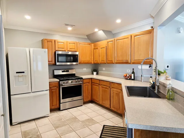 a kitchen with stainless steel appliances granite countertop a refrigerator stove microwave and sink