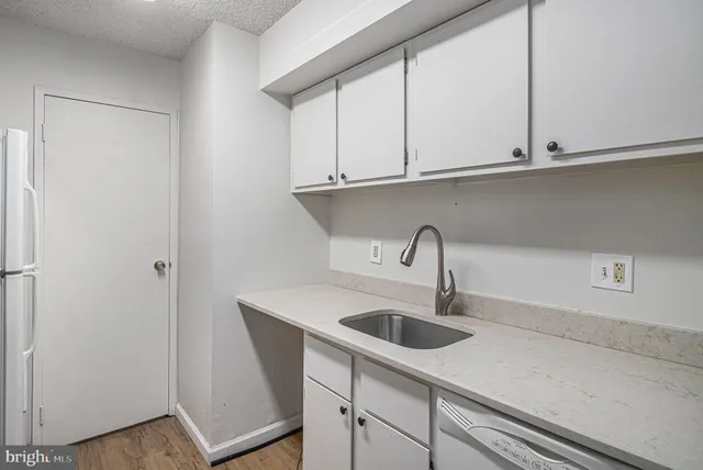 a kitchen with stainless steel appliances granite countertop white cabinets sink and dishwasher