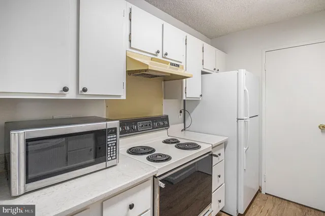 a kitchen with cabinets and a stove top oven