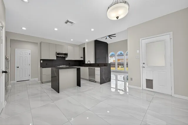 a kitchen with stainless steel appliances granite countertop a refrigerator and a sink