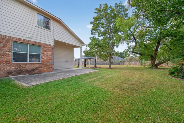 a view of a house with backyard and a tree