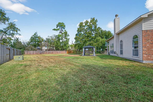 a backyard of a house with table and chairs