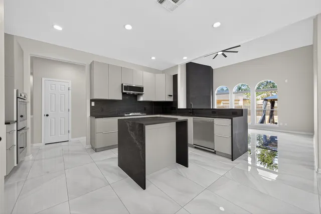 a kitchen with a sink a counter top space and stainless steel appliances