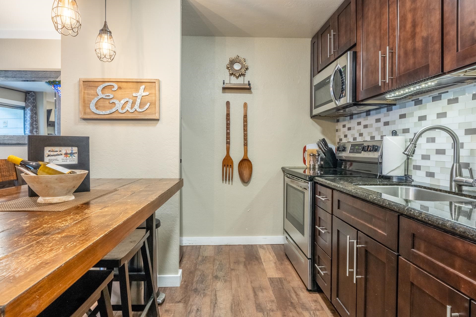 2289 Sierra Nevada Road, Unit F4 Mammoth Lakes, CA 93546 - Photo 13 of 22 a kitchen with stainless steel appliances granite countertop a sink stove and cabinets