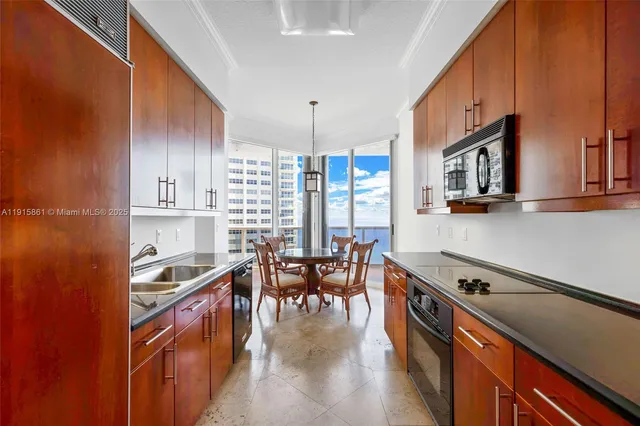 a kitchen with stainless steel appliances granite countertop a stove oven a dining table and chairs with wooden floor