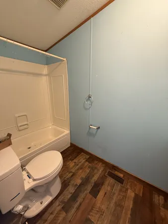 a bathroom with a toilet and a shower