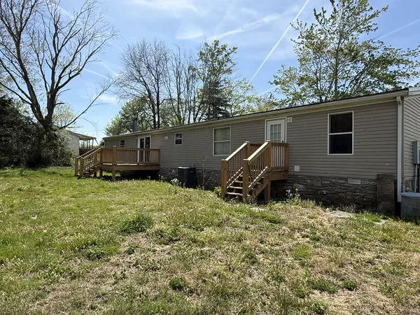 a backyard of a house with wooden fence and trees