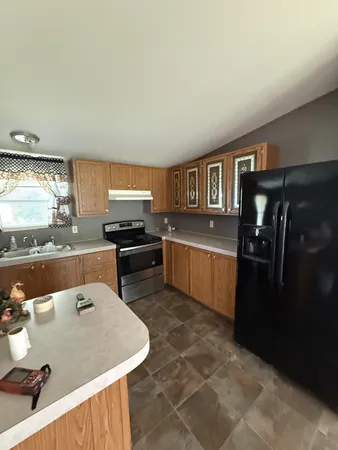 a kitchen with stainless steel appliances granite countertop a sink a stove and refrigerator