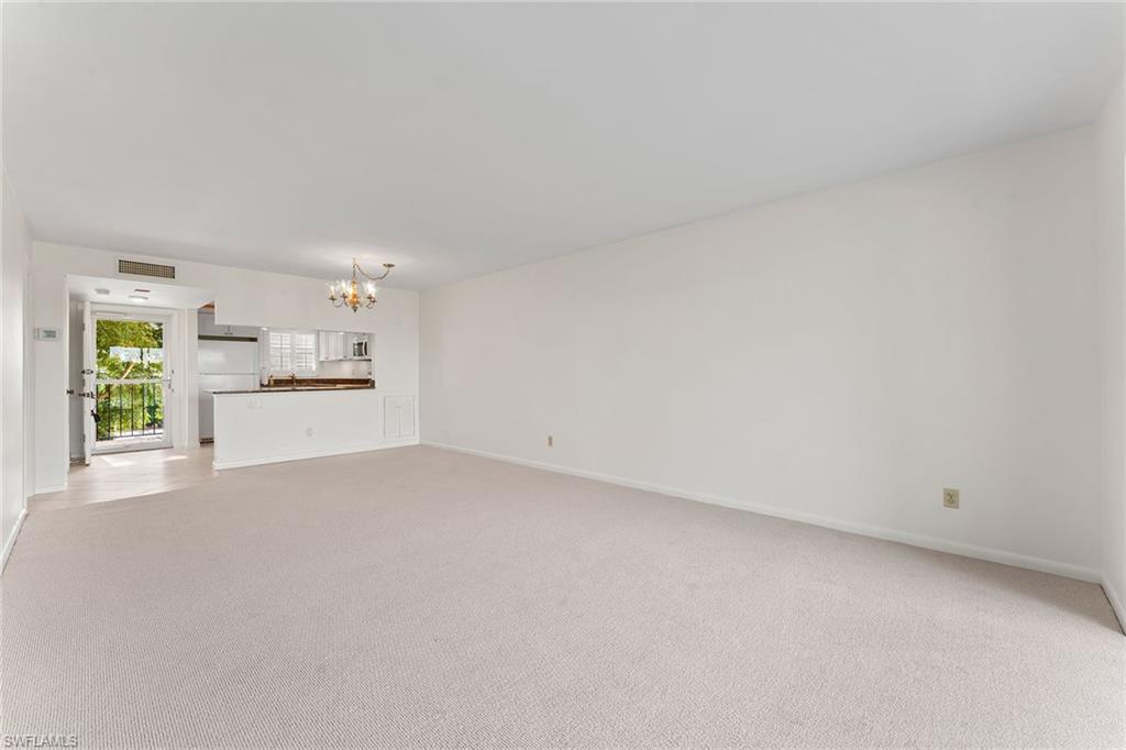 37 High Point Circle East, Unit 307 Naples, FL 34103 - Photo 12 of 20 a view of a kitchen with a sink and dishwasher a stove top oven with white cabinets