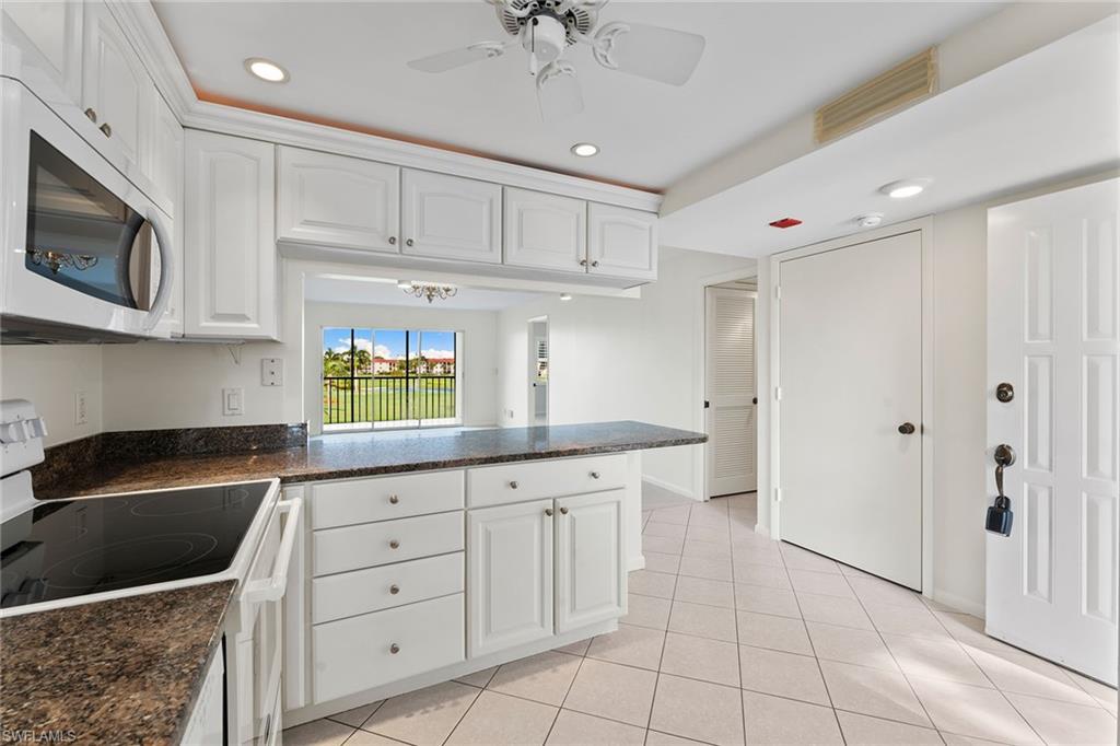 37 High Point Circle East, Unit 307 Naples, FL 34103 - Photo 9 of 20 a kitchen with granite countertop a sink a stove and cabinets