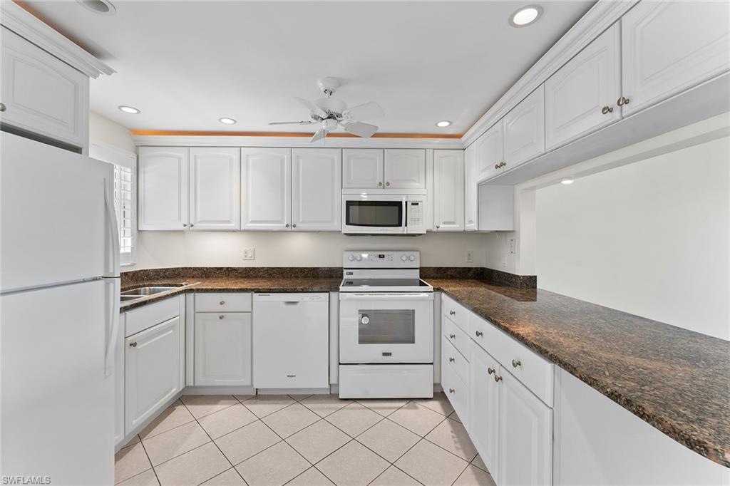 37 High Point Circle East, Unit 307 Naples, FL 34103 - Photo 10 of 20 a kitchen with granite countertop white cabinets white stainless steel appliances and a sink
