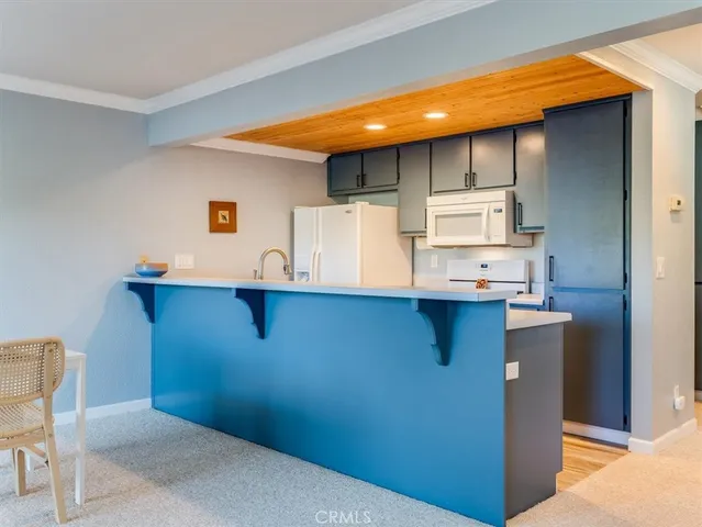 a kitchen with kitchen island a stove a sink and a refrigerator