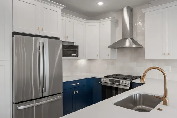 a kitchen with stainless steel appliances granite countertop a refrigerator sink and stove