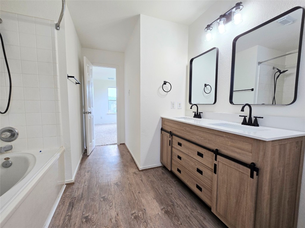22911 Twisting Maple Court Spring, TX 77373 - Photo 17 of 37 a bathroom with a double vanity sink a mirror a bathtub and shower
