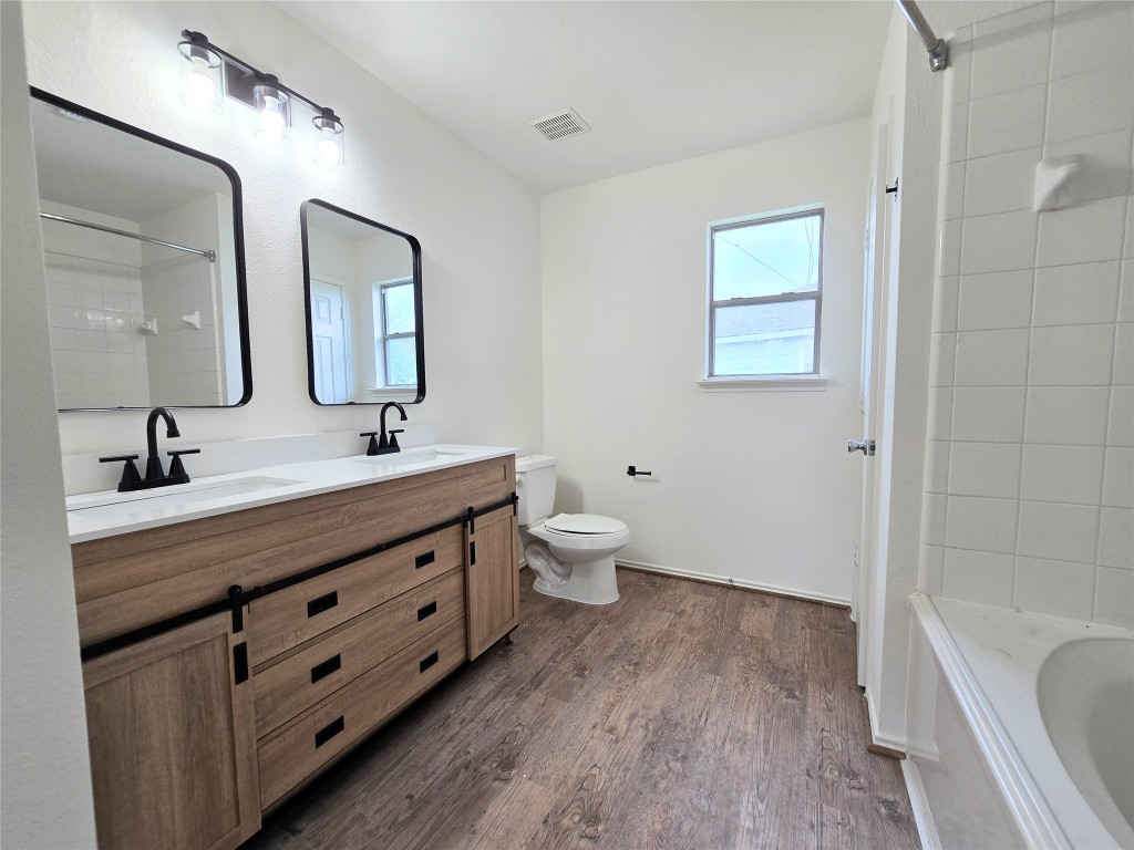 22911 Twisting Maple Court Spring, TX 77373 - Photo 18 of 37 a bathroom with a double vanity sink a toilet a shower and a mirror
